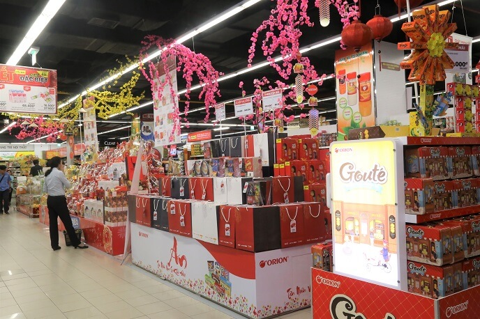 Đường dẫn siêu thị được trang trí nổi bật với hoa mai - đào cùng các món hàng mang màu sắc tết